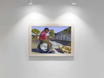 African boy sitting on a car tyre in the street.