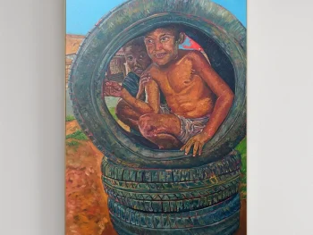 A boy sitting inside a large car tyre with his friend catching the viewers gaze.